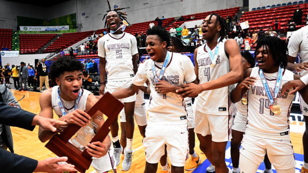 Miami Norland players celebrate after receving the Class 5A state championship basketball trophy on Friday after beating Tampa Blake for the title at the RP Funding Center.